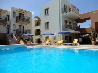 a swimming pool with chairs and umbrellas in front of a building at Alexandros M in Maleme