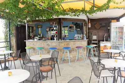 a bar with tables and stools in front of it at Alexandros M in Maleme