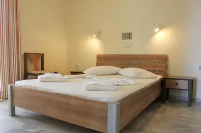 a bedroom with a large bed with towels on it at Alexandros M in Maleme