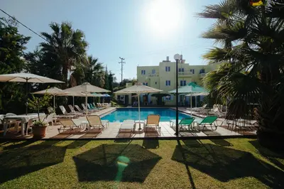 a swimming pool with lounge chairs and umbrellas at Kalithea Apartments - Heated Pool in Kalyves