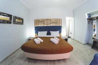 a bedroom with a bed with two pink pillows on it at Dome Rooms Downtown in Chania Town