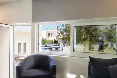 a living room with a chair and a window at Forum Suites in Kato Daratso