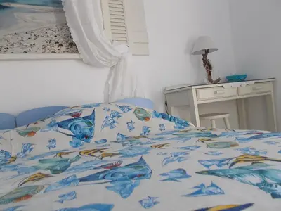 a bed with a blue comforter with fish on it at Dimitra's Sea-Crafts Boutique Studios in Kalyves