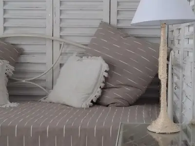 a table with a lamp and a couch with pillows at Dimitra's Sea-Crafts Boutique Studios in Kalyves