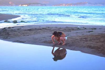 a woman is playing in the sand on the beach at Dimitra's Sea-Crafts Boutique Studios in Kalyves