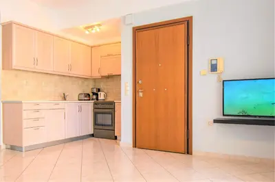 a kitchen with a door and a television on a wall at Chania Central Flat in Chania Town