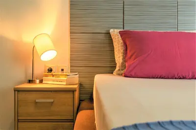 a bedroom with a bed and a night stand with a lamp at Chania Central Flat in Chania Town