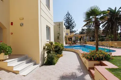 a building with a swimming pool and a resort at Lambrinos Suites in Plataniás
