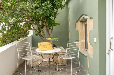 a small table with chairs and a box on it at Grandma's Nest in Kissamos