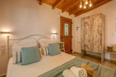 a bedroom with a large white bed with blue pillows at Vitis Vinifera Tranditional Studio Apartment in Kissamos