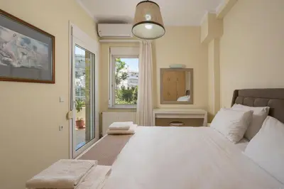 a bedroom with a large white bed with a window at Natalia Guest House in Chania Town