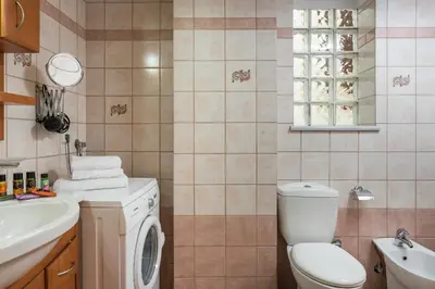 a bathroom with a toilet and a sink and a washing machine at Natalia Guest House in Chania Town
