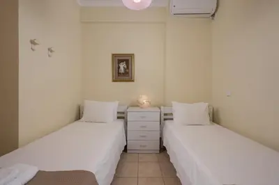 two beds in a room with white walls at Natalia Guest House in Chania Town