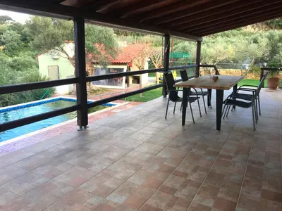 a patio with a table and chairs and a pool at Chania Village - Charoupia & Daphne Villas Private Pool - BBQ - Afrata in Afráta