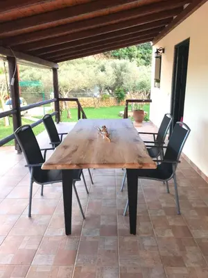 a wooden table and chairs on a patio at Chania Village - Charoupia & Daphne Villas Private Pool - BBQ - Afrata in Afráta