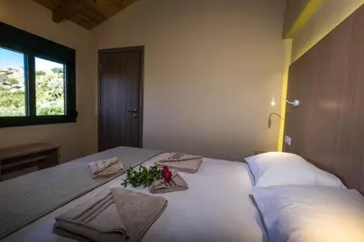 a bedroom with a large white bed with flowers on it at Chania Village - Charoupia & Daphne Villas Private Pool - BBQ - Afrata in Afráta