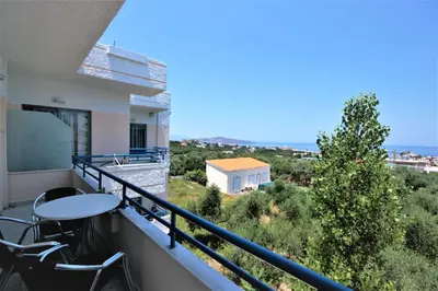 a balcony with a table and chairs and the ocean at Balito in Kato Galatas