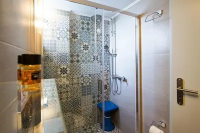 a shower with a blue stool in a bathroom at Balito in Kato Galatas