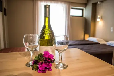 a bottle of wine and two glasses on a table at Nireas Hotel in Kato Daratso