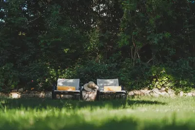two chairs sitting in the grass in a field at Dionyssos Village in Kato Daratso
