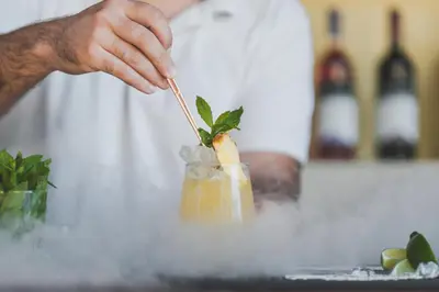 a person stirring a cocktail with a stick at Dionyssos Village in Kato Daratso