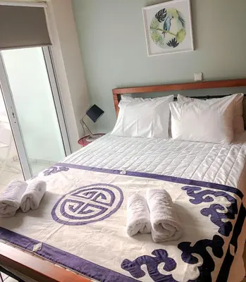 a bedroom with a bed with towels on it at Sofia City Beach 3 Apts Nea Chora Chania steps from the beach in Chania Town