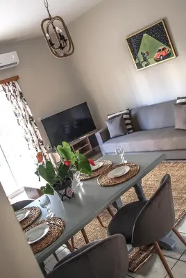 a living room with a table and a couch at Sofia City Beach 3 Apts Nea Chora Chania steps from the beach in Chania Town