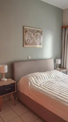 a bedroom with a bed and a picture on the wall at Sofia City Beach 3 Apts Nea Chora Chania steps from the beach in Chania Town