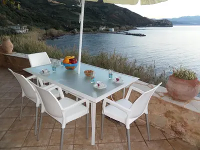 a table with chairs and an umbrella on a patio at Endless Blue in Ravdhoúkha