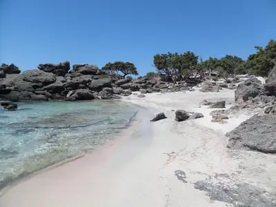 a sandy beach with rocks and the water at Endless Blue in Ravdhoúkha