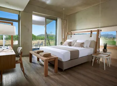 a bedroom with a large bed and a large window at Youphoria Beach Front Villas in Korfalónas