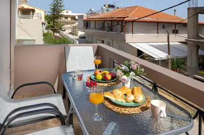 a table with a plate of food on a balcony at Katerina Apartments in Kato Daratso