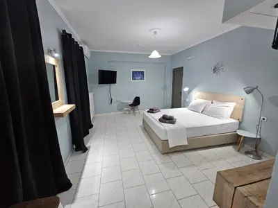 a bedroom with a bed and a tv in it at Katerina Apartments in Kato Daratso