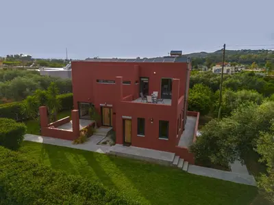 an aerial view of a red house with a yard at Red Castle in Souda