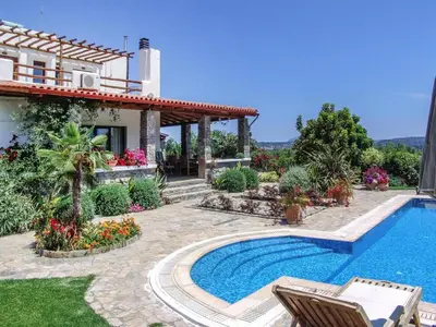 a villa with a swimming pool in front of a house at Private Pool & Garden Villa for 6 in Pemónia