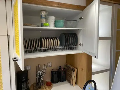 a kitchen cabinet with plates and utensils in it at Papaduke House in Kalyves