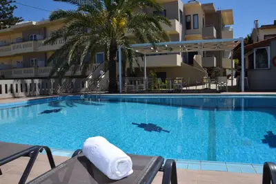 a hotel swimming pool with a towel on a chair at Amaryllis in Plataniás