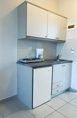 a kitchen with white cabinets and a counter top at Amaryllis in Plataniás