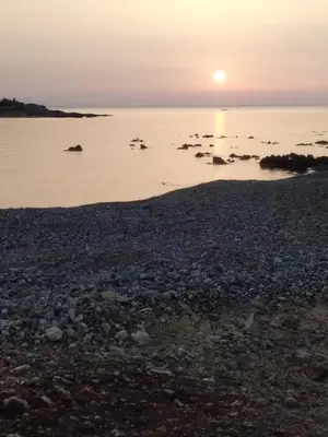 a sunset over the water with birds in the water at Sea Side House Rapanas in Falasarna