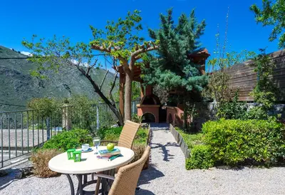 a table and chairs in a garden with a tree at Apirathes Residence in Zoúrva