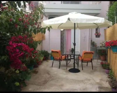 a patio with a table and chairs under an umbrella at Konstantina's studio near the beach in Chania Town