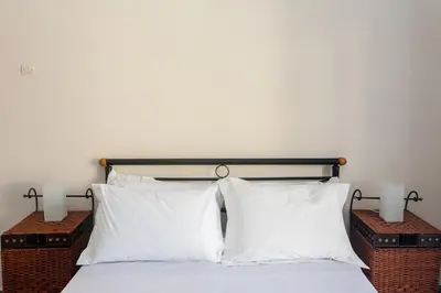 a bed with two white pillows and two lamps at Apartment in Koomkapi in Chania Town