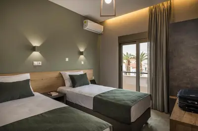 a hotel room with two beds and a window at Mirma Luxury Apartment in Chania Town