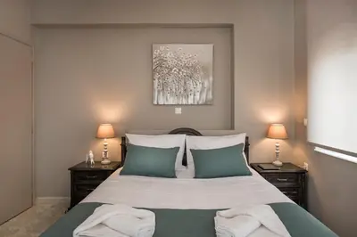 a bedroom with a large bed with two lamps at Mirma Luxury Apartment in Chania Town