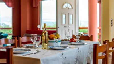 a table with a bottle of wine and glasses on it at Villa Helen 200m from the beach in Tersanas BY APOKORONAS-VILLAS in Tersanas