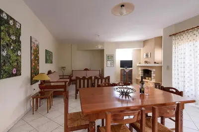 a dining room and living room with a table and chairs at Niki's Apartment in Palaiochóra