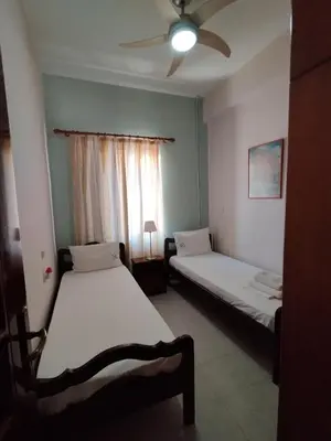 a bedroom with two beds and a ceiling fan at Aromatic Home in Kissamos