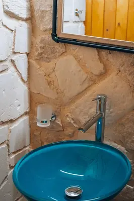 a blue sink in a bathroom with a stone wall at Villa Stafidaki in Stalos