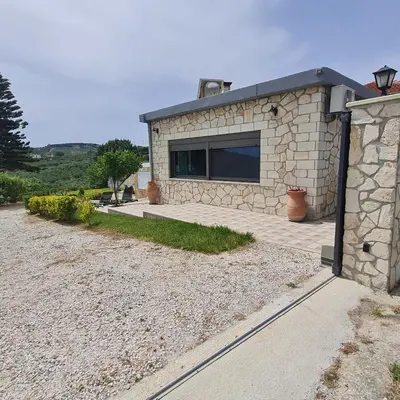 a stone house with a window and a driveway at Archontiko Haris in Kolymvari
