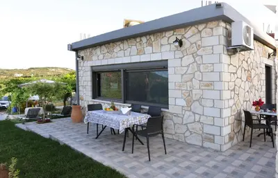 a patio with a table and chairs in front of a building at Archontiko Haris in Kolymvari
